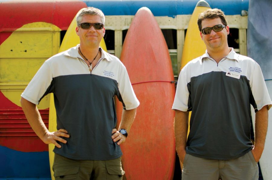 Brad Mosesitt, owner of Mountain Whitewater Descents, and Ben Costello, manager, stand in front of kayaks on their business' property. Mountain Whitewater Descents has had to close for the first time in its 12 year history due to the Hewlett Gulch and High Park Fires.
