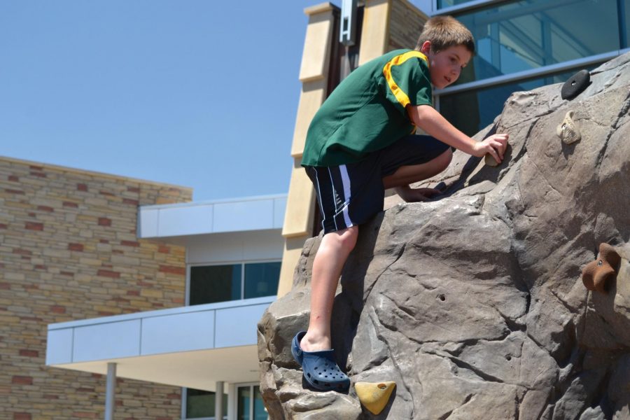 Eleven-year-old Scotty Chase, climbs the boulder problem in front of the CSU recreation center. Scotty and his family are from Littleton, Colo. and are visiting the CSU campus while his older sister attends Preview Orientation.