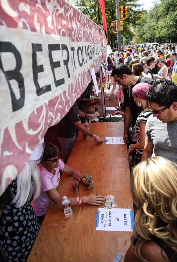 Patrons purchase beers tokens from a tent at the 2012 Tour de Fat in Old Town Saturday afternoon. The annual ride and festival attracts more than 20,000 costume-clad riders to cruise around the streets of Old Town Fort Collins. 
