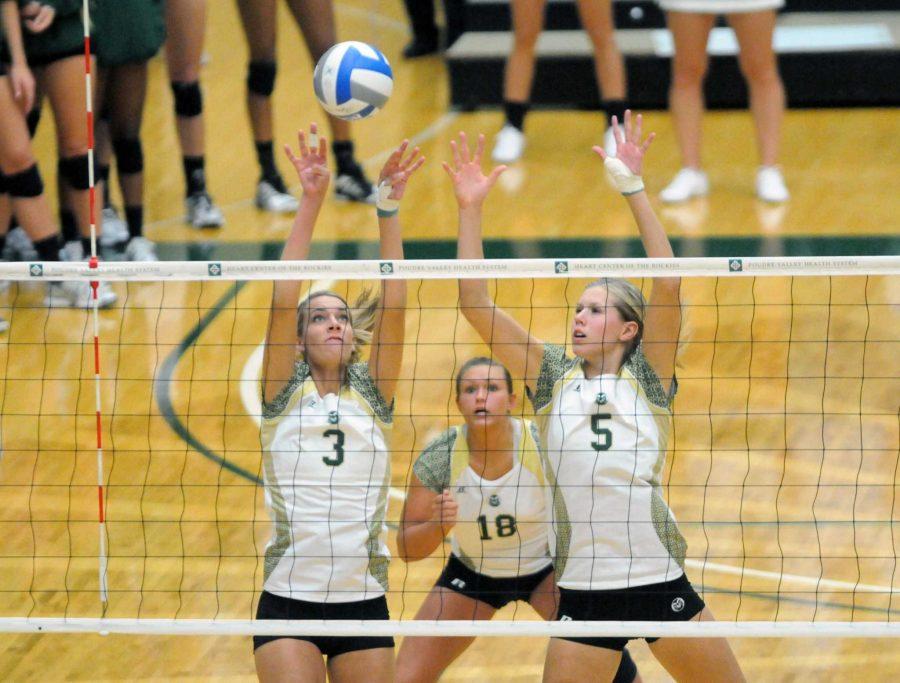 Tori Brummett, 3, and Megan Plourde, 5, try to block a Nebraska spike as Deedra Foss, 18, prepares to hit the ball if the block is unsuccessful.