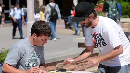 Kevin Kruglet, left, is assisted by voter registration volunteer Will Minton while filling out his Colorado voter registration form in 2010 on the Plaza outside of the Lory Student Center.