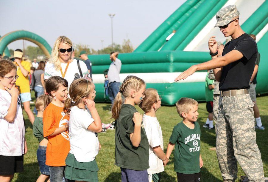 Sophmore political science major and ROTC cadet Logan Gappa directs young rams into the bouncy castle at the Ag Day celebration before the football game at Hughes Stadium Saturday afternoon. The annual alumni barbque gets together past and present Rams in an effort to raise scholorship money for for students.