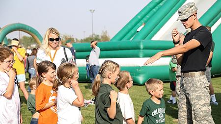 Sophmore political science major and ROTC cadet Logan Gappa directs young rams into the bouncy castle at the Ag Day celebration before the football game at Hughes Stadium Saturday afternoon. The annual alumni barbque gets together past and present Rams in an effort to raise scholorship money for for students.