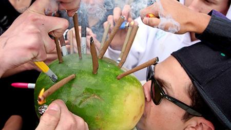Alex Foster, from Colorado Springs, takes a toke on a hollowed-out watermelon loaded with marijuana blunts on 420 in Boulder as friends and complete strangers provide combustion. Amendment 64, passed yesterday,  legalizes the individual possession of an ounce of marijuana.