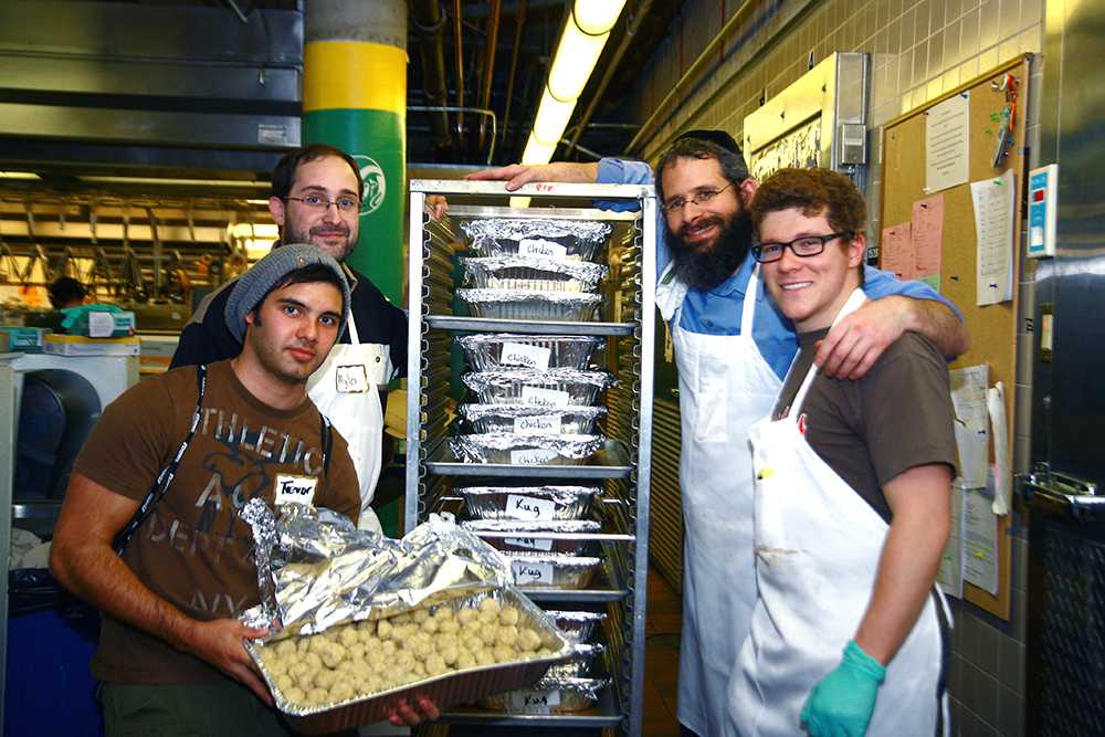 From left: Trevor Heyman, Myles Sedgwick, Rabbi Yerachmiel Gorelik, and Michael Lichtbach prepare food for the Shabbat Dinner on Wednesday afternoon. The dinner will be held Friday night at 7 pm. in the Lory Student Center Main Ballroom.