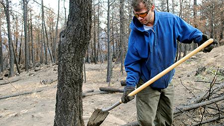 Pedro Boscan, a Colorado State professor, cleans up the remains of his house after the Rist Canyon fire. Boscan is rebuilding his house with help from neighbors in the community.