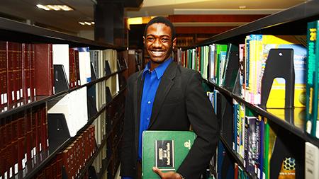 Nigel Daniels, president of the Pre-law club, stands in the law section of the library Monday afternoon. Although many law students believe there is little to no hope for getting a job in law upon graduation, Daniels still has hope as he gets ready to take the LSAT next year.
