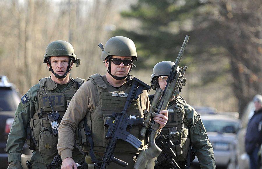 FBI SWAT team members walk along Dickinson Drive near Sandy Hook Elementary School in Newtown, Connecticut, Friday, December 14, 2012. Twenty-seven people, including 18 children, have been killed in a shooting at Sandy Hook Elementary School. (Cloe Poisson/Hartford Courant/MCT)