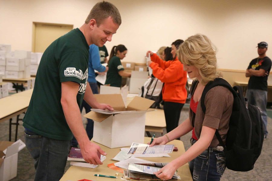 Freshman journalism major Breamma Haas, right, picks up reserved books from sophmore mechanical engineering major David Presley in the North Ballroom of the Lory Student Center Tuesday afternoon. Textbook reservation is available to any student through the bookstore offering a quick, convinient way to get textbooks.