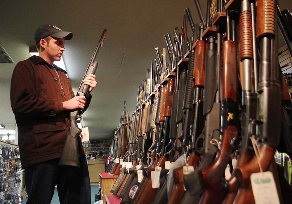 Wildlife Biology major Sam Peterson browses through the shotgun collection at the Rocky Mountain Shooter Supply off of Mulbery Tuesday afternoon. The store reports an increase in gun sales since the recent Sandy Hook shootings.