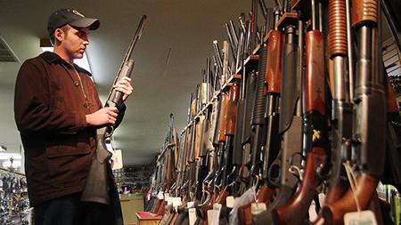 Wildlife Biology major Sam Peterson browses through the shotgun collection at the Rocky Mountain Shooter Supply off of Mulbery Tuesday afternoon. The store reports an increase in gun sales since the recent Sandy Hook shootings.