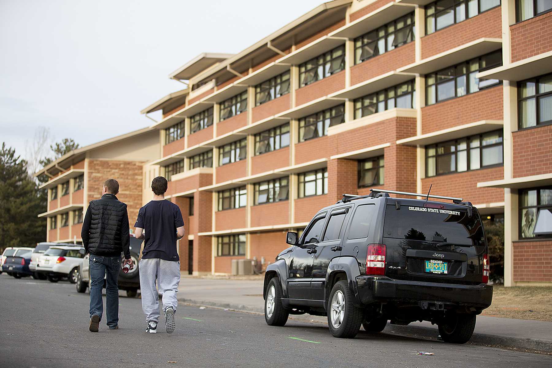 Freshmen Mark Currie, left, and Ben Boucher walk past the Corbett parking lot to their dorm Sunday evening. Starting today, the Corbett parking lot will be closed to make room for Laurel Village, the new student housing project scheduled to be completed in Fall of 2014.