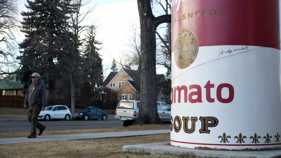 A Fort Collins Resident walks past the rusting Andy Warhol Tomato Soup Can Monday. The Soup can will be temporarily removed from the University Center for the Arts for restoration.