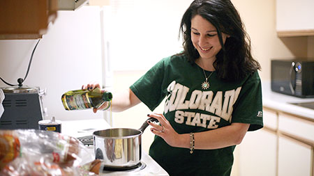 Sophomore equine and animal science major Rebecca Sonn makes dinner at her apartment in Rams Village east Monday night. Sonn moved off campus after living in Braiden Hall her first year.