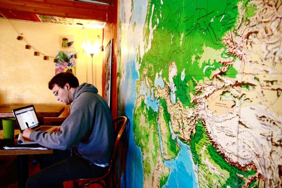 Fort Collins local and recent graduate, Soren Peterson, enjoys warm tea while applying to various jobs Monday morning at the Alley Cat.