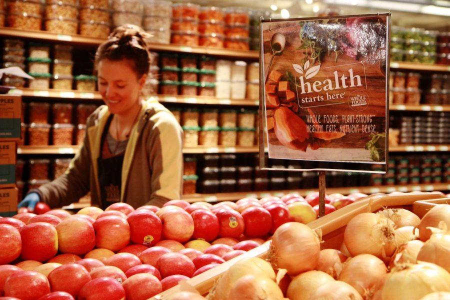 A Whole Foods employee unloads fresh apples in the produce department. Whole Foods purchases their produce from local growers to provide the healthiest, freshest, and most environmentaly friendly produce local Fort Collins community members can get.