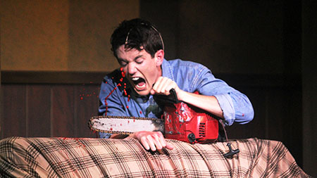 Seth Klusmire cuts off his own hand with a chainsaw after it started attacking him during the Evil Dead rehearsal on Wednesday.