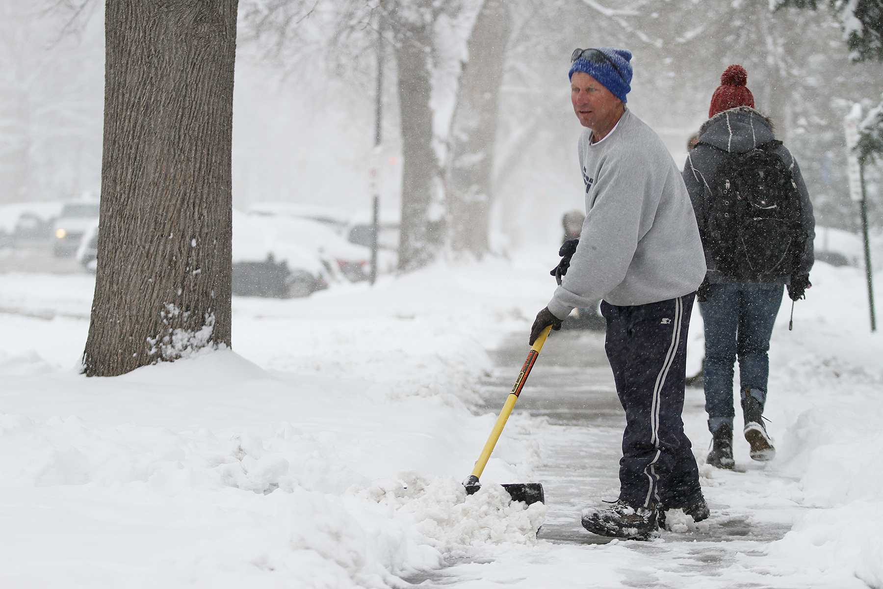 Dave Dean shovels snows off his sidewalk on Meldrum on Monday afternoon.