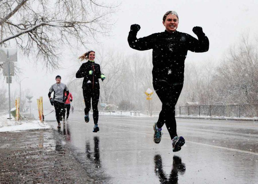 Allie Mossing raises her arms up in victory as she finishes a snowy stride for the Fort Collins Boston Strong run. The 3-4 mile run started and ended at New Belgium Brewery and was organized to support the victims of the Boston bombing.