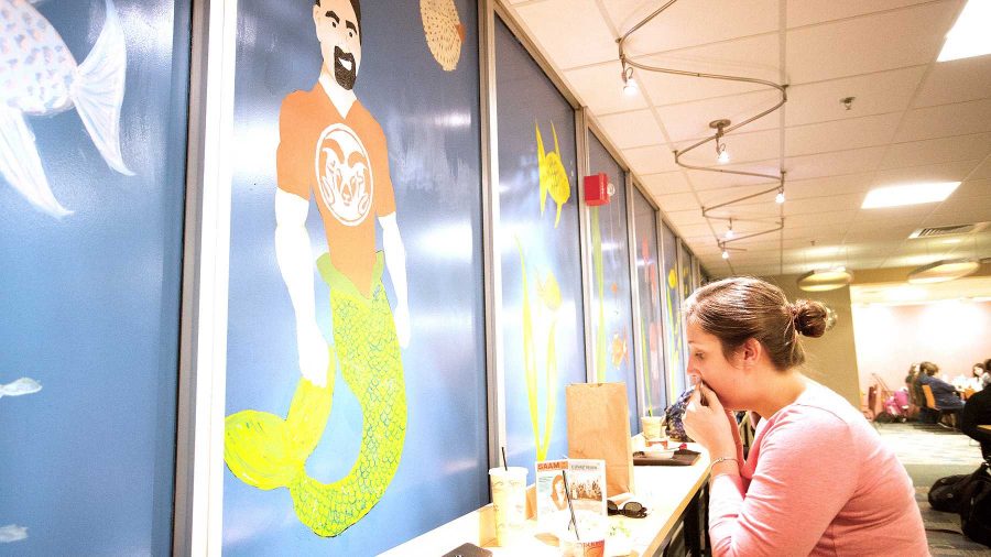 Kailey Buttrick eats lunch in front of the mural featuring Tony Frank as a mermaid in the LSC foodcourt last week. Key Service Community students were responsible for painting the masterpiece.