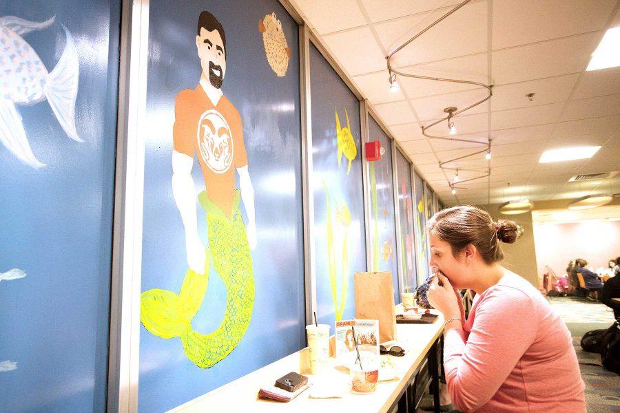 Kailey Buttrick eats lunch in front of the mural featuring Tony Frank as a mermaid in the LSC foodcourt last week. Key Service Community students were responsible for painting the masterpiece.