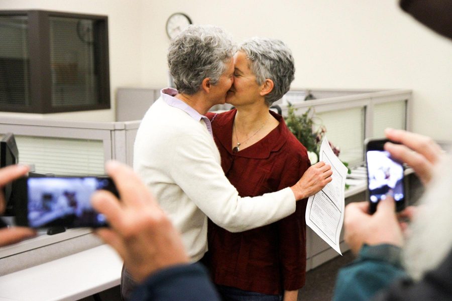 Family and friends take pictures of Ellen Brinks and Jules Horton kissing for the first time as a legally recognized Civil Union in the Larimer County Courthouse in Fort Collins on Wednesday morning. Brinks clutches the newly signed document in her right hand.