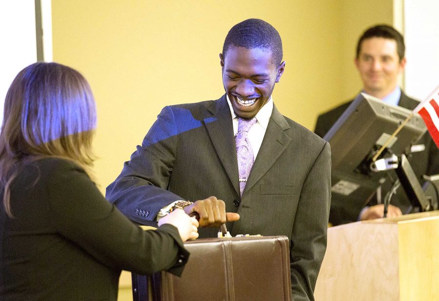 Former ASCSU President Regina Martel, left, hands off a presidential suitcase to President Nigel Daniels just before he was sworn in at Senate Wednesday night in the computer science building. The suitcase is passed along, and only seen, by the ASCSU presidents.