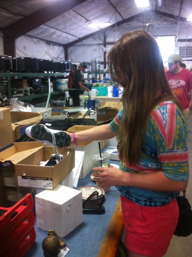Angela Bennick, employee of INTO CSU, looks at a pair of cleats that were left behin for the Tent Sale, Sunday. The Surplus Tent Sale brought in over $21,000 in sales for the Eco Leader Program at CSU. Photo By Logan Martinez