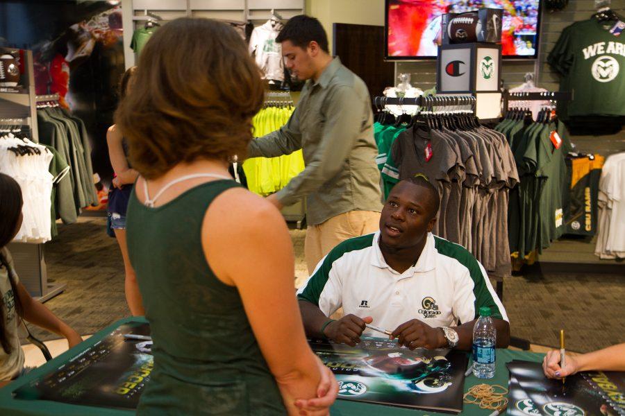 CSU Volleyball player Kelsey Snider, Soccer player Jami Vaughn, and Football player Chris Nwoke sign posters for Ram Fans at the Ram Zone in Old Town.