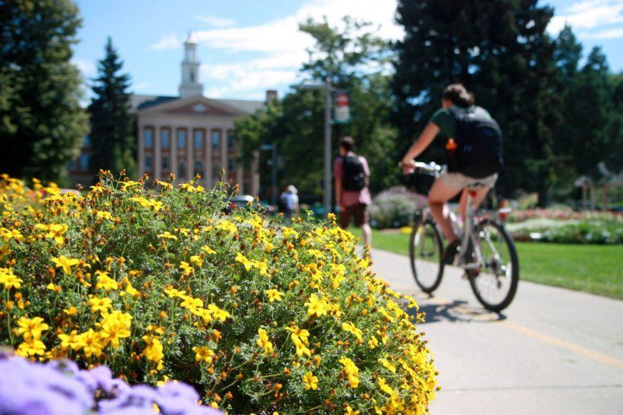 Students zip through the vibrant UCA garden on Wednesday afternoon on their way to and from campus.