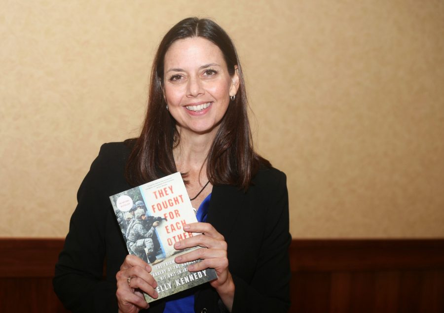 CSU Alum Kelly Kennedy takes a moment after her lecture Wednesday afternoon to pose with her book They Fought for Each Other. Kennedy is a journalist and a Desert Storm Veteran whose book describes the frontlines of Iraq through following the experience of the Charlie Company of the 26th Regiment.