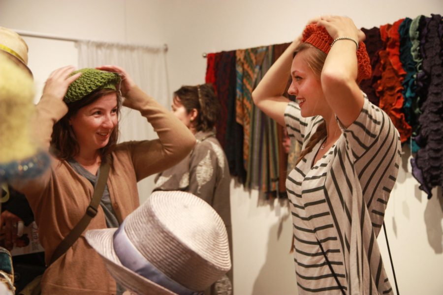 CSU art students, Leah Walker and Molly Wilson, try on hats made by local artists during the ArtWear Fashion show this past Friday. Walker helped set up for the event, held by the Lincoln Center, and was pleased to have something different and fun for her and a friend to do within the Fort Collins community.