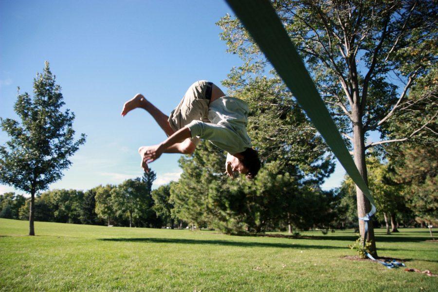 Junior Buisness major, Travis Paul, rips out a gnarly backflip off of a slackline in City Park. Travis has been slacklining for two years, and has even done some high-lining out in California.