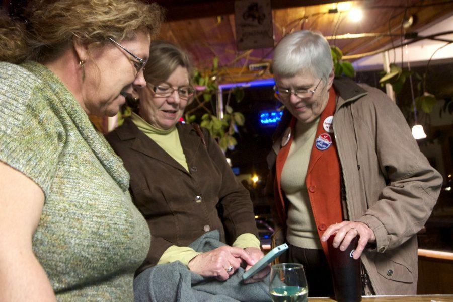 Martha Coleman, Linda Gabel, and Barabra Barr look at election updates on their Iphone. All three women volunteered to help David Trask run for Director of Poudre School District.