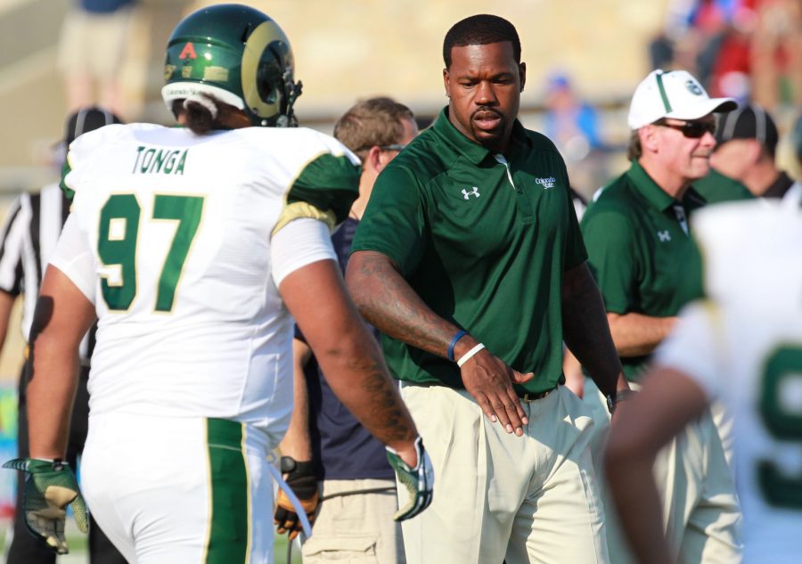 Assistant undergraduate coach Joey Porter congratulates defensive lineman Calvin Tonga (97). Porter was inducted into the  CSU athletics Hall of Fame at halftime of Saturday's game against Boise State. He was drafted into the NFL in 1999 by the Pittsburgh Steelers, where he won Super Bowl XL and was named a four-time Pro Bowler.