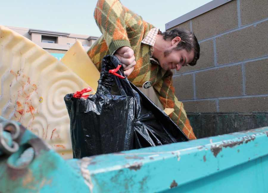 John Rooss, a soil and crop science major and organic agriculture minor, searches for goodies in his neighborhood dumpster. According to Rooss, in addition to using his findings for personal projects he also recycles and composts items that he finds.