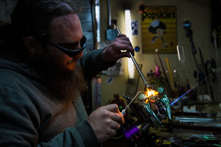 Skye Perry, co-owner of Glass Antixx, works on a hand-blown piece of glass art at his studio.