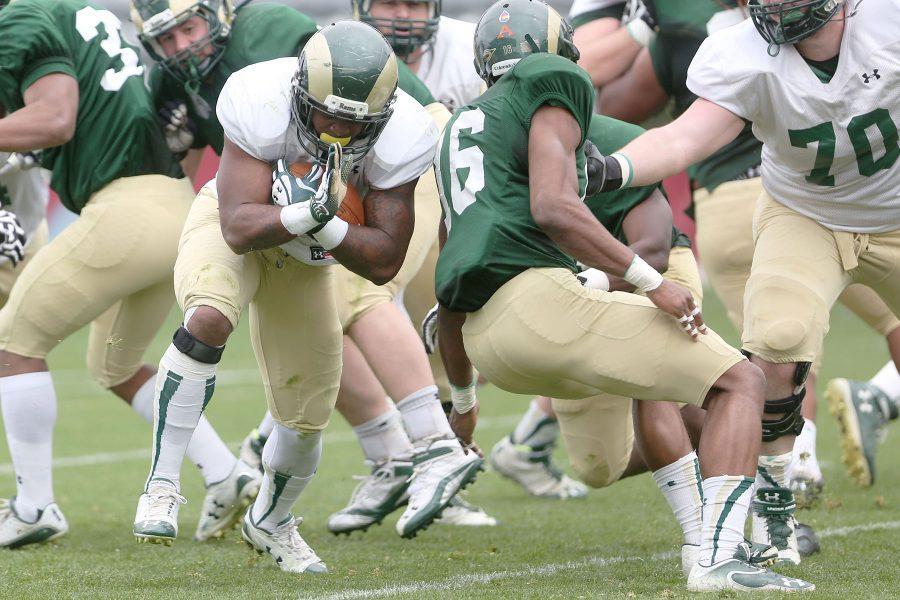 Jasen Oden, 10, weaves between defenders during Saturday's scrimmage in Denver. Oden is currently making the transition from safety to running back.