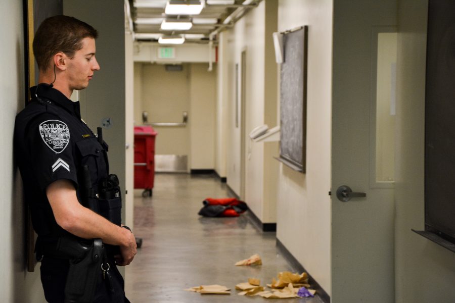 A CSU police officer stands watch outside a lab on the third floor of the Chemistry building where an explosion reportedly happened. Paper towels and drops of blood cover the floor of the hallway behind him.