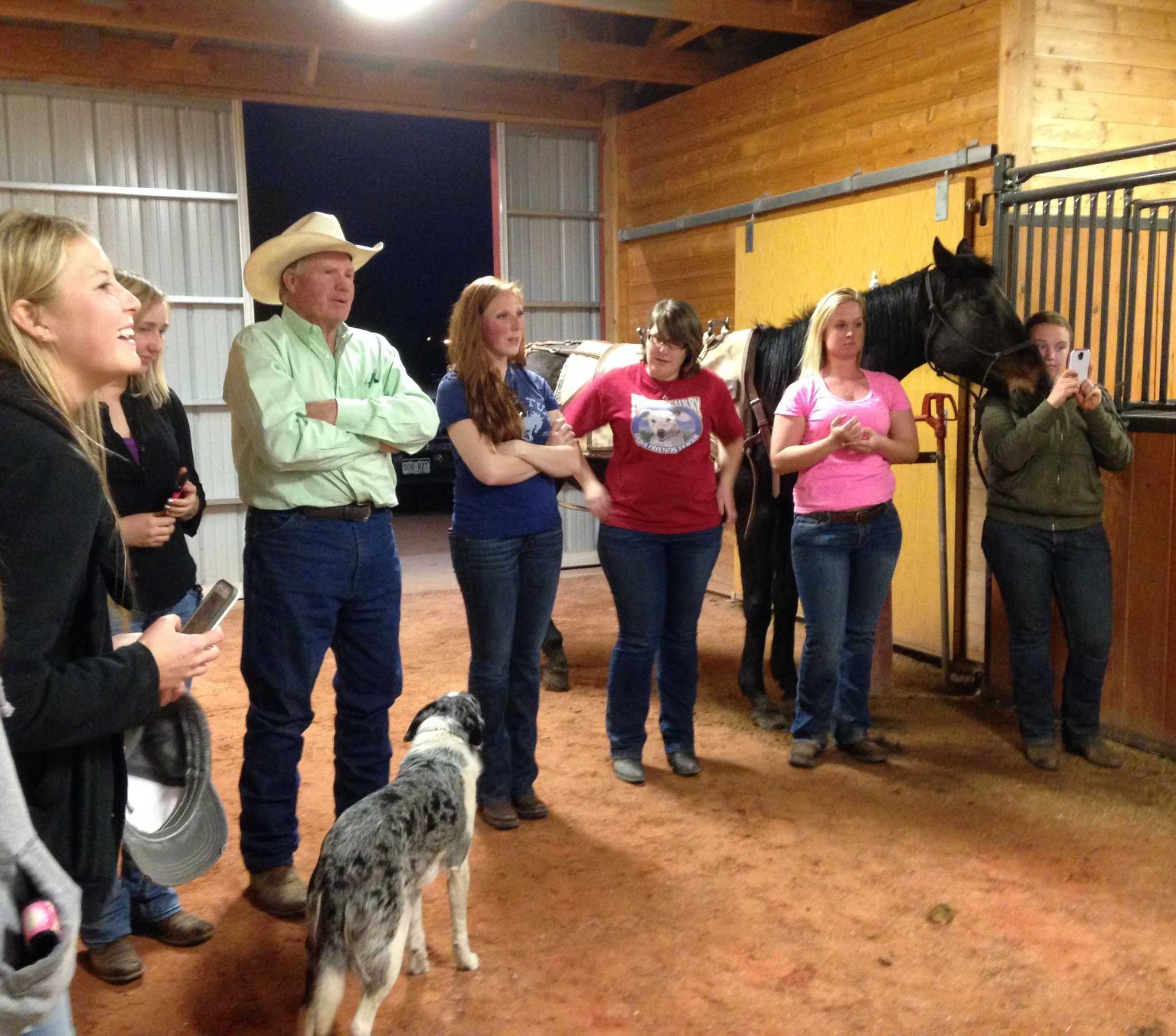 Mountain Rider Horse Club members and advisor Chuck Peterson, watch as Chuck directs the packing  demonstration. (Photo by Dixie Crowe)