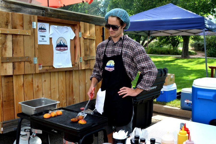 Kyle Abbott flips some grilled peaches while working at the Bears Backyard Grill food truck.