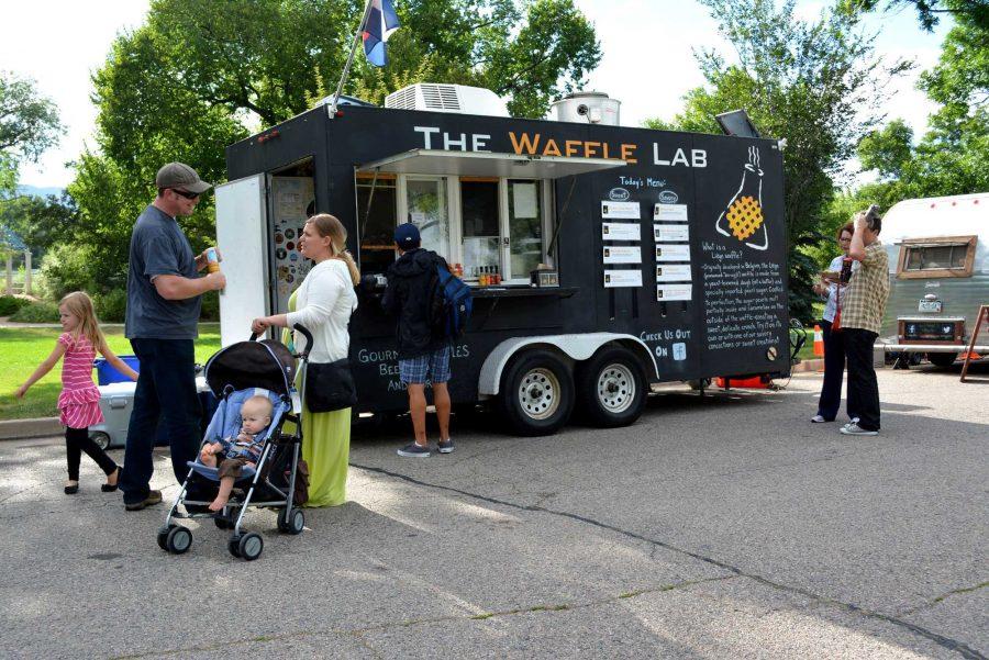 People gather around the Waffle Lab at the Fort Collins Food Truck Rally at City Park. (Photo credit: Collegian File Photo) 