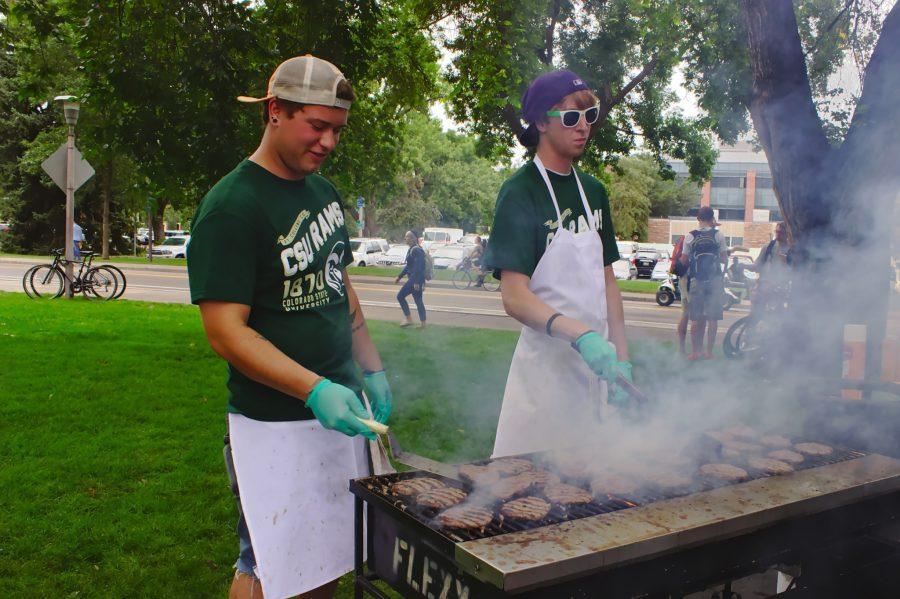 (right to left) Lory Student Center Catering employees Evan Macy and Aaron Hickey grill the buffalo burgers at the corner of West Plum Street and Meridian Avenue during Grill the Buffs
