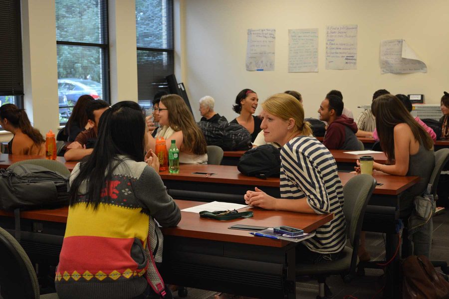 Becky Butler, a senior majoring in international studies talks with INTO student Lydia Cheung who studies natural resource management. The two shared perspectives on the assigned topic for the day, which was homelessness. (Photo Credit: Megan Fischer)
