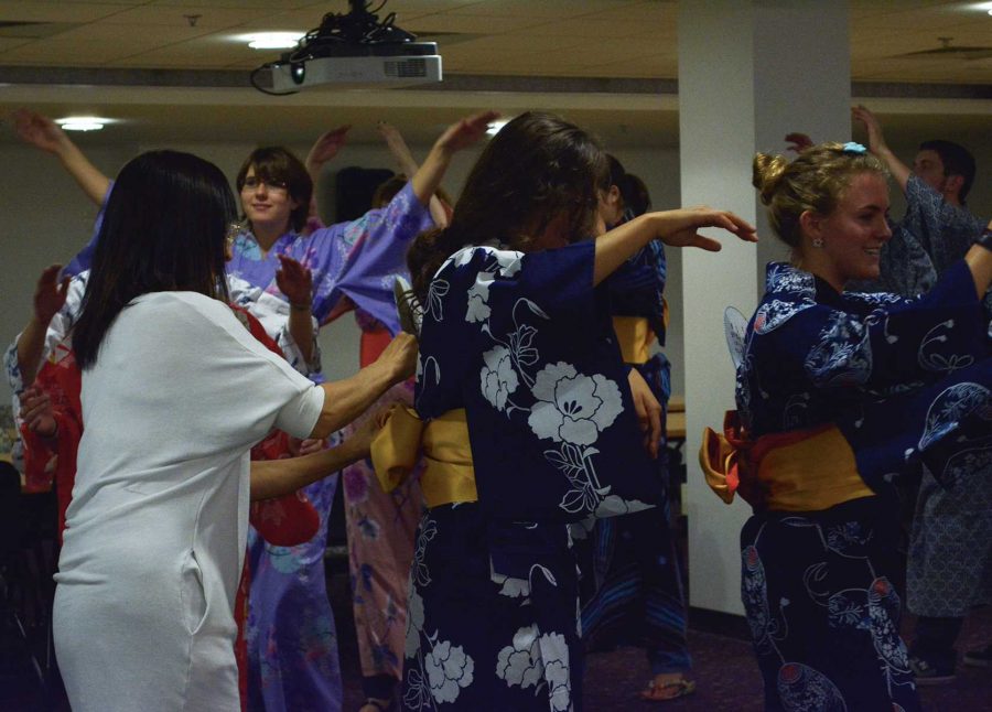 Mako Beecken, a Japanese language instructor here at CSU, sticks fans into the backs of the students kimonos.