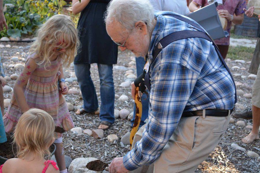 Bob Geller, founder of the Geller Center, puts dirt in the  the hole where they composted the original mortgate. The Geller Center has officially bought the land from the Synod of the Rocky Mountains of the Presbyterian Church. (Photo Credit: Megan Fischer)