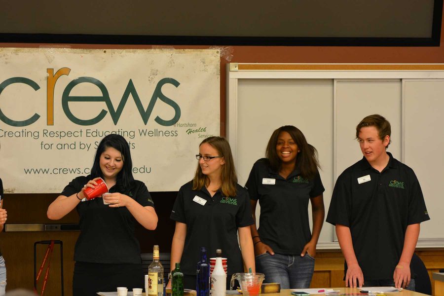 Junior criminology major, Tracy Bullington, junior psychology major, Anastasia Soroka, junior zoology major, Ashley Bankhead and sophomore mechanical engineering major, Matt Illa show students how one big class of alcohol can really be amny shot-sized glasses as a part of crews meeting Wednesday. (Photo Credit: Megan Fischer)