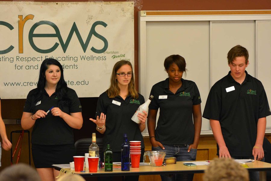 Junior criminology major, Tracy Bullington, junior psychology major, Anastasia Soroka, junior zoology major, Ashley Bankhead and sophomore mechanical engineering major, Matt Illa show students how one big class of alcohol can really be amny shot-sized glasses as a part of crews meeting Wednesday. (Photo Credit: Megan Fischer)