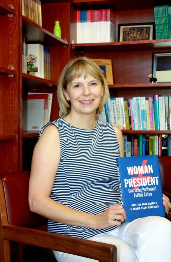Dr. Karrin Anderson holds her book, Woman President, in her office. (Photo Credits: Hannah Ditzenberger) 