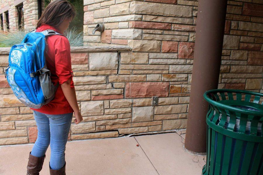 Freshman art major Holly Flechsig looks at the cracks surfacing in the Summit residence hall due to settling in the foundation post construction. 